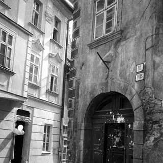Historic European street with arched entrance and old buildings.