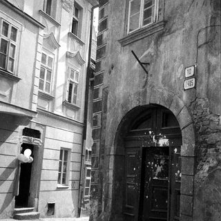 Historic European street with arched entrance and old buildings.