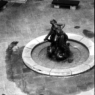 "Courtyard fountain with classical statue and modern sculpture."