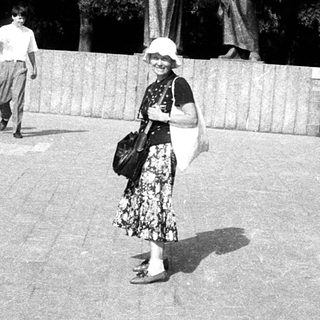 People walking near historical statues in park.