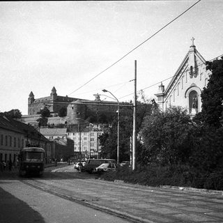 Historic town street with castle ruins and church.