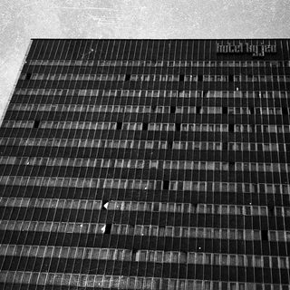 Grid of solar panels on ground.