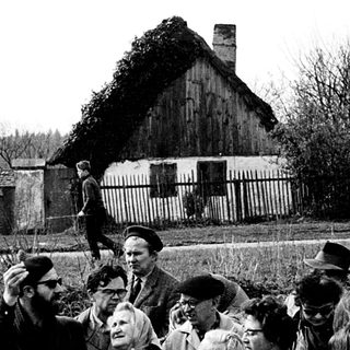 Group of people gathered outdoors during a public speech or event.