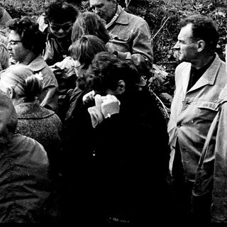 Group of people gathered outdoors during a public speech or event.