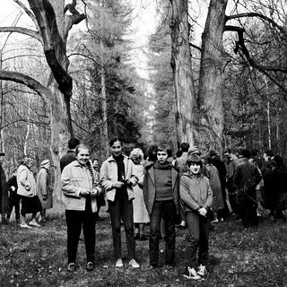 Group of people posing outdoors in a wooded area.