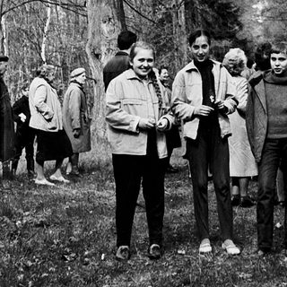 Group of people posing outdoors in a wooded area.