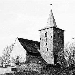 Historic stone church with tall bell tower.