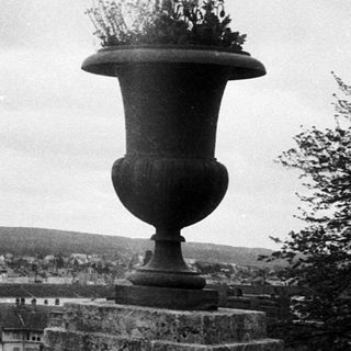 Vintage view of town with bridge and flower vase.