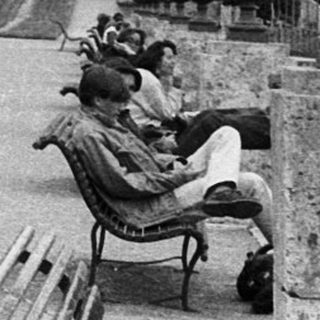 Peaceful park scene with people walking and sitting.