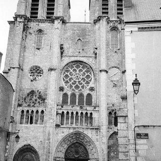 Gothic cathedral façade with rose window and twin towers.