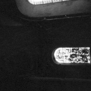 Small boat near large ship at night.