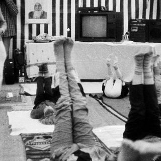 People upside down in a confined, striped room.