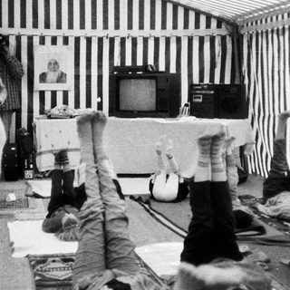 People upside down in a confined, striped room.