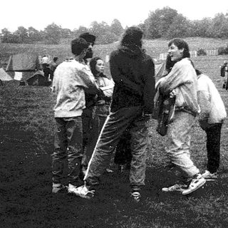 People camping outdoors in a field with tents.