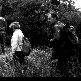 People hiking near a rocky cliff.