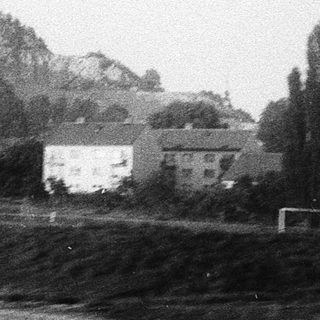 Rural landscape with houses, hills, and soccer field.