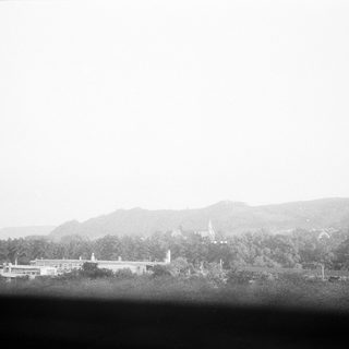 Vintage view of rural buildings and misty hills.