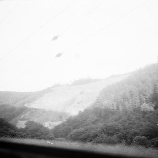 Mountainous landscape with mist and power lines.