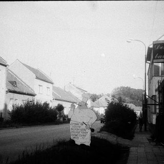 Vintage street scene with protest sign near bar.