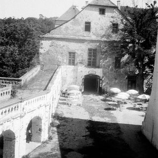 Historic stone building with arched bridge and courtyard.