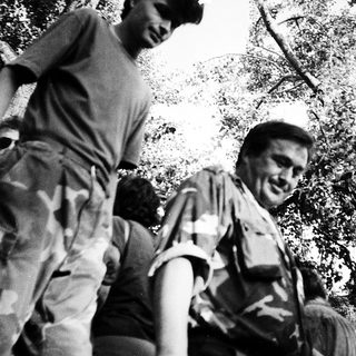 Two men laughing while hiking outdoors.