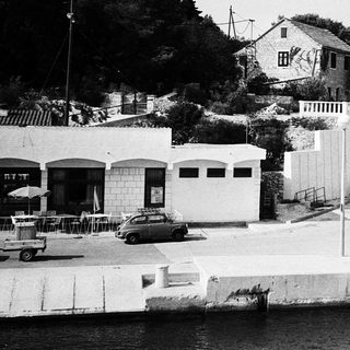 Historic seaside building complex with cars.