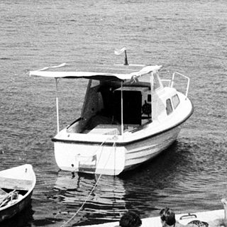 Boats docked near shoreline with people relaxing.