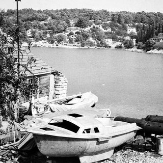 War-damaged coastal area with wrecked boats and artillery.