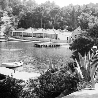 Luxury lakeside resort with person walking near waterfront.