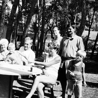 Family picnic in a forested campsite.