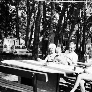 Family picnic in a forested campsite.