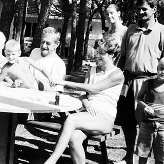 Family picnic in a forested campsite.