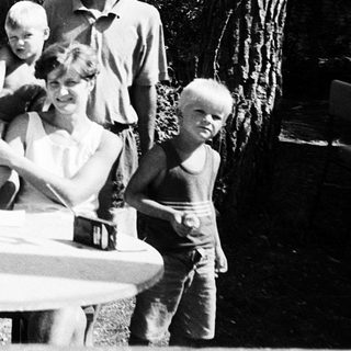 Family gathering outdoors in a wooded area.