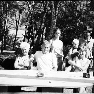 Family gathering outdoors in a wooded area.