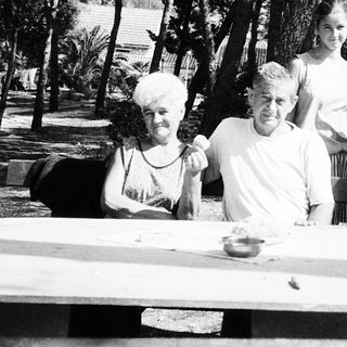 Family gathering outdoors in a wooded area.