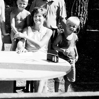 Family gathering outdoors by a picnic table.