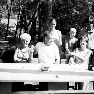 Family gathering outdoors by a picnic table.