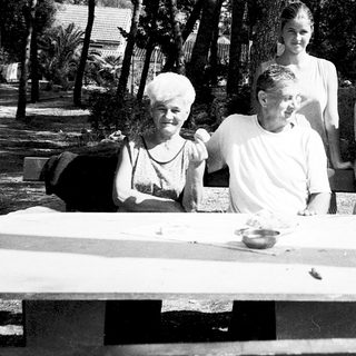 Family gathering outdoors by a picnic table.