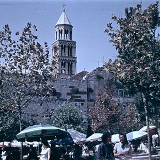 Historic bell tower with market stalls below.