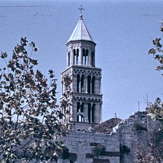 Historic bell tower with market stalls below.