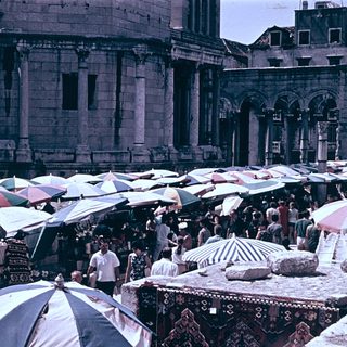 Historic square with bustling outdoor market stalls.