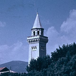 Historic coastal town with bell tower by waterfront.