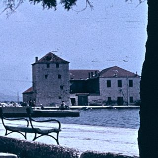 Coastal town scene with waterfront buildings and laundry.