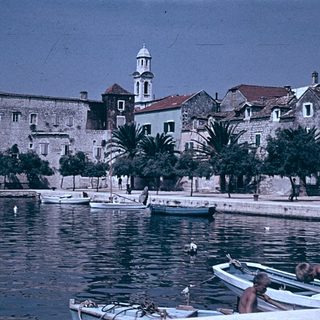 Historic coastal town with boats and old stone buildings.