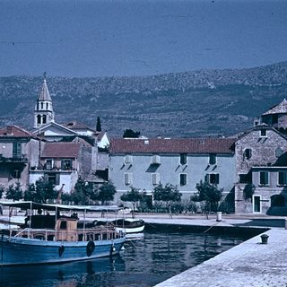 Coastal village with historic buildings and boats.