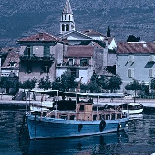 Coastal village with historic buildings and boats.