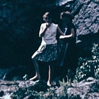 A person standing near a powerful waterfall.