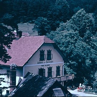 Rural village scene with historic inn and lush countryside.