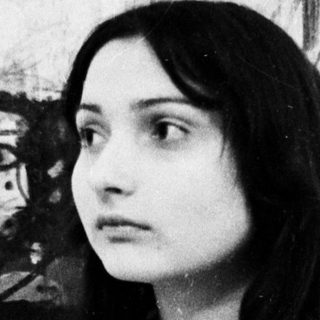 Woman posing in front of abstract artwork.