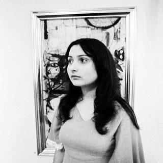 Woman posing in front of abstract artwork.